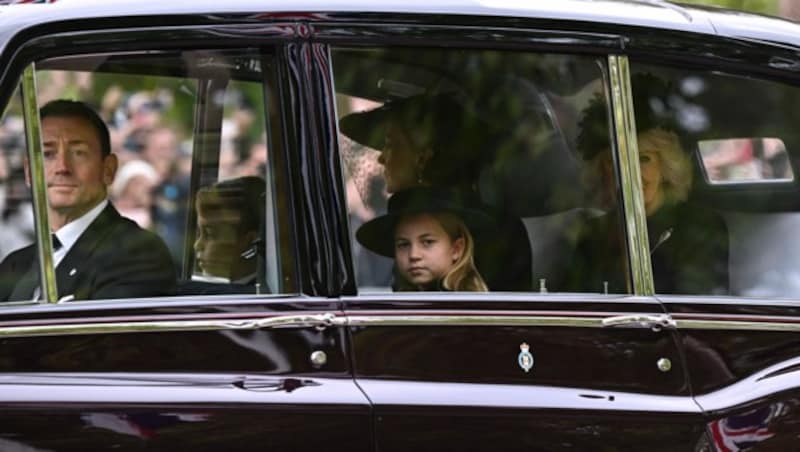 Prinz George und Prinzessin Charlotte mit Prinzessin Kate und Königin Camilla im Auto (Bild: APA/Photo by Paul ELLIS/AFP)