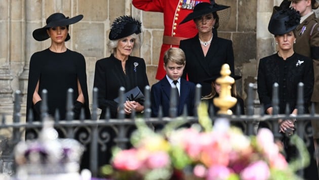 Herzogin Meghan, Königin Camilla, Prinz George, Prinzessin Kate und Gräfin Sophie beobachten den Sarg von Queen Elizabeth, als er aus der Westminster-Abtei gebracht wird. (Bild: APA/(Photo by Oli SCARFF/AFP)