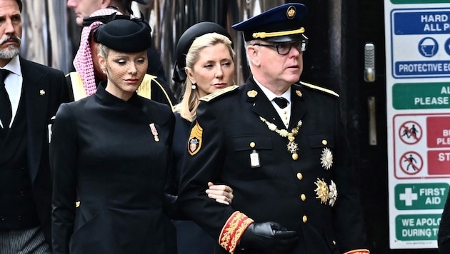Fürstin Charlene hat sich am Begräbnis der Queen bei Fürst Albert eingehakt. (Bild: APA/Photo by Marco BERTORELLO/AFP)