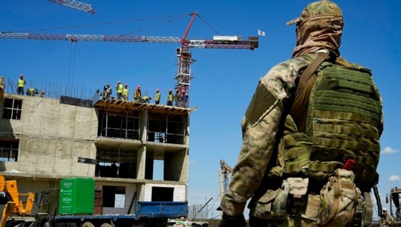 Ein russischer Soldat bewacht eine Baustelle im besetzten Mariupol. (Bild: AP)