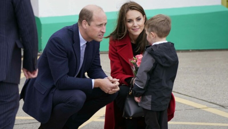 Der Prinz und die Prinzessin von Wales werden von dem kleinen Buben mit Blumen in der Rettungsboot-Station Hoylhead in Wales begrüßt. (Bild: Danny Lawson / PA / picturedesk.com)