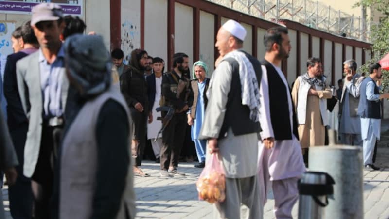 Taliban-Kämpfer stehen Wache, während sich Menschen vor einem Krankenhaus in Kabul versammeln, um nach Angehörigen zu suchen. (Bild: AFP)