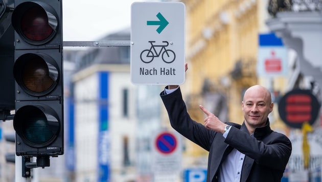 Der Linzer VP-Stadtvize und Mobilitätsreferent Martin Hajart präsentiert stolz die Tafel, die es Bikern ab Samstag an der Kreuzung Landstraße / Bürgerstraße erlaubt, bei Rot rechts abzubiegen. (Bild: Horst Einöder/Flashpictures)