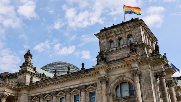 Die Regenbogenfahne ziert am Christopher Street Day den Reichstag in Berlin (Bild: APA/Photo by DAVID GANNON/AFP)