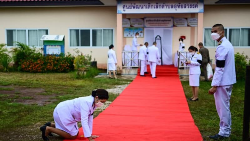 Am Tatort wird ein roter Teppich für König Maha Vajiralongkorn ausgerollt, der sich am Tag nach der Tat angekündigt hatte. (Bild: AFP)