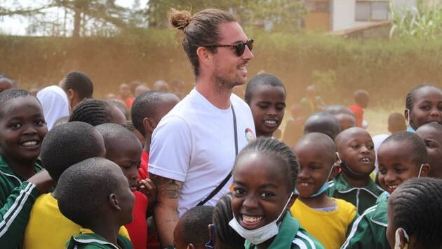 Andreas Schobersberger (Mitte) mit afrikanischen Kindern, die sich in der Nähe von Nairobi über einen Fußballplatz freuen. (Bild: Andreas Schobersberger)