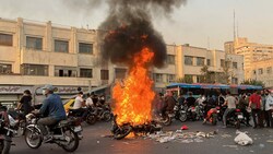 Im Zuge der Proteste wurde ein Motorrad angezündet. (Bild: AFP )