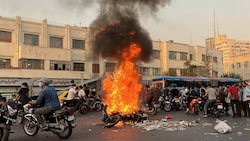 Im Zuge der Proteste wurde ein Motorrad angezündet. (Bild: AFP)