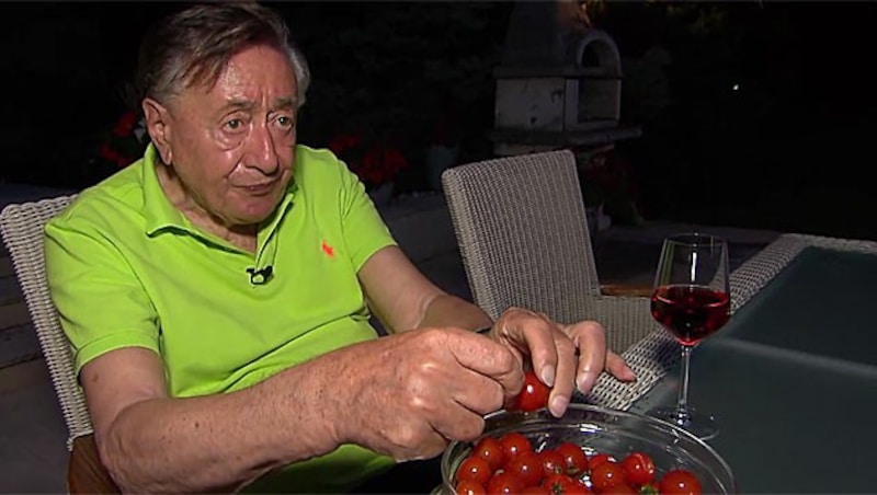 Biobauer Richard Lugner gönnt sich ein Glas Wein und Tomaten, die er selbst angebaut hat. (Bild: krone.tv)