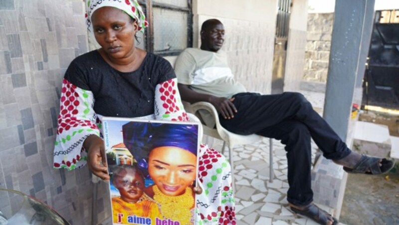 Mariama Kuyateh (30) hält ein Bild ihres verstorbenen Sohnes Musawho hoch, der an akutem Nierenversagen gestorben ist. (Bild: APA/AFP/MILAN BERCKMANS)