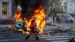 Ein Sanitäter läuft an einem brennenden Auto nach einem russischen Angriff in Kiew vorbei. (Bild: The Associated Press)