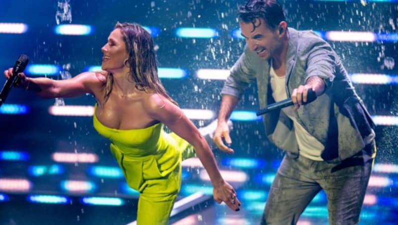 Helene Fischer und Moderator Florian Silbereisen tanzen bei „Das große Schlagerjubiläum 2022“ in Leipzig im Regen. (Bild: Hendrik Schmidt / dpa / picturedesk.com)