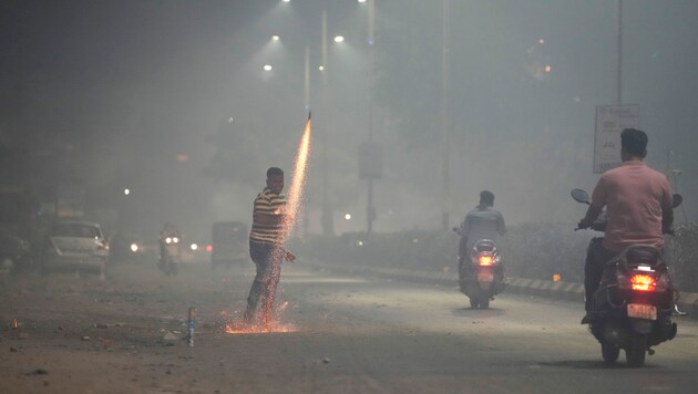 Ein Inder zündet anlässlich des Lichterfests Diwali ein Feuerwerk. (Bild: Associated Press)