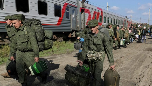 Russische Soldatinnen und Soldaten nehmen einen Zug in Prudboi (Bild: AP)