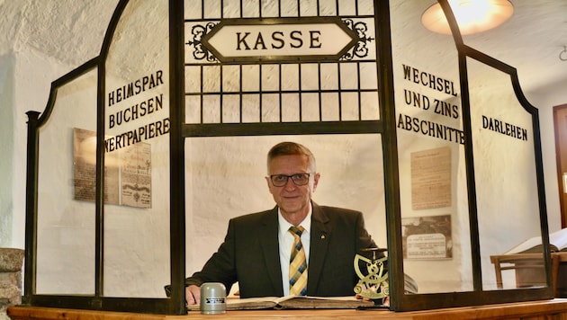 Reinhold Weikertschläger sits behind a historic cash desk, which can also be seen in the First Austrian Savings Bank Museum. (Bild: 1. Österreichisches Sparkassenmuseum Groß Siegharts)