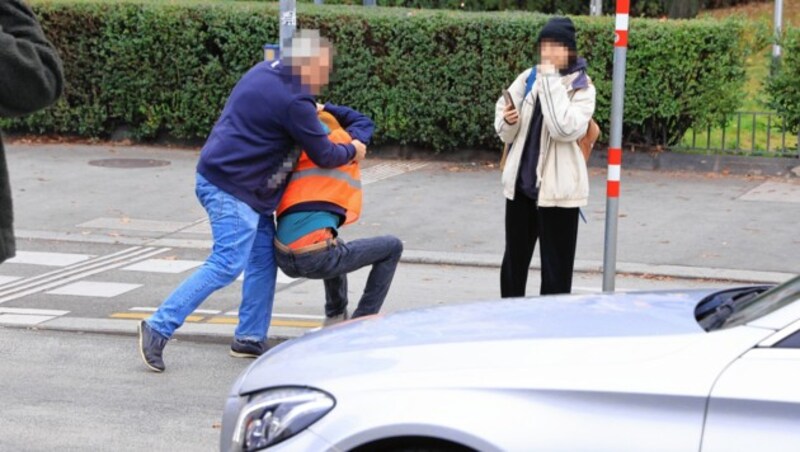 Ein Autofahrer beförderte einen der Aktivisten von der Straße. (Bild: Zwefo, Krone KREATIV)