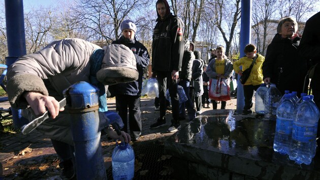 Kiews Bewohnerinnen und Bewohner füllten nach dem Ausfall der Wasserversorgung in einem Park Wasser in Plastikflaschen ab. (Bild: AFP)