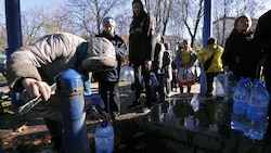 Kiews Bewohnerinnen und Bewohner füllten nach dem Ausfall der Wasserversorgung in einem Park Wasser in Plastikflaschen ab. (Bild: AFP)