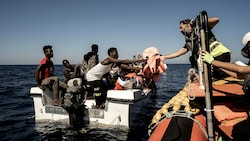Mitglieder der Ocean-Viking-Crew bei der Aufnahme von gestrandeten Migranten (Bild: APA/AFP/Vincenzo CIRCOSTA)