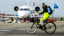 Klima-Aktivisten blockieren ein Flugzeug am Flughafen Schiphol. (Bild: APA/(Photo by Remko de Waal/ANP/AFP)