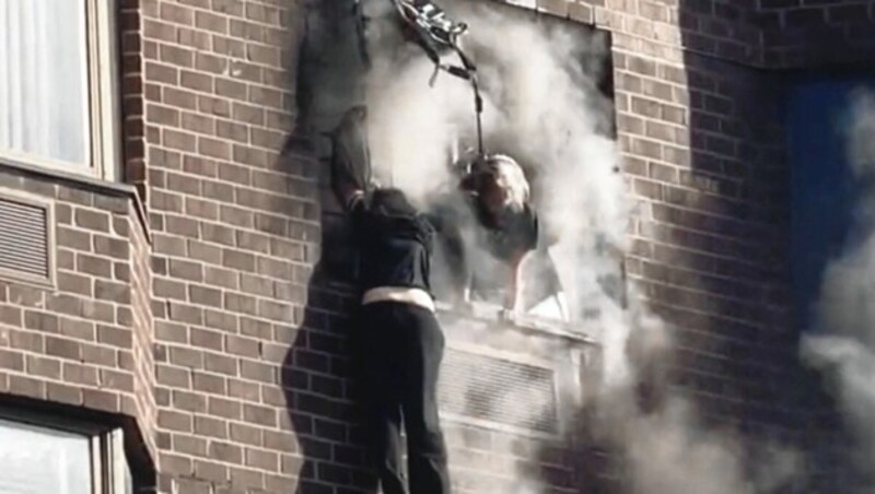 Zwei Personen versuchen aus dem Fenster einer brennenden, verqualmten Wohnung in einem New Yorker Hochhaus zu entkommen. (Bild: MARIUSZ KORECKI via REUTERS)