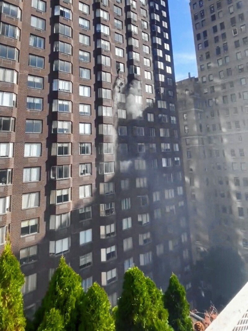 Feuerwehrleute retten eine Frau aus einem Fenster der brennenden Wohnung. (Bild: MARIUSZ KORECKI via REUTERS)