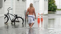 Anwohner müssen durch die Überschwemmungen spazieren, die von den Regenbändern des Hurrikans verursacht wurden. (Bild: ASSOCIATED PRESS)
