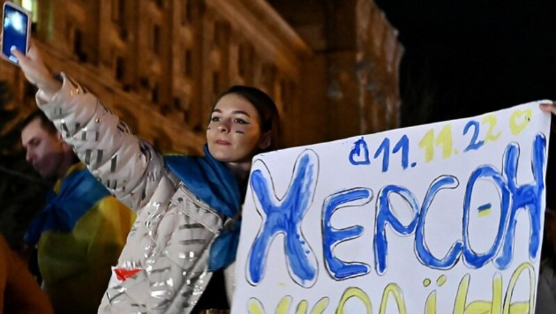 Cherson gehört seit dem 11. November 2022 wieder zur Ukraine, verkündet diese Ukrainerin auf ihrem Transparent am Maidan in Kiew. (Bild: APA/AFP/Genya SAVILOV)