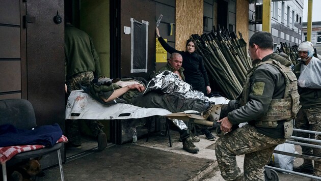 Ukrainische Soldaten transportieren in der Region Donezk einen verwundeten Kollegen in ein Spital. (Bild: Associated Press)
