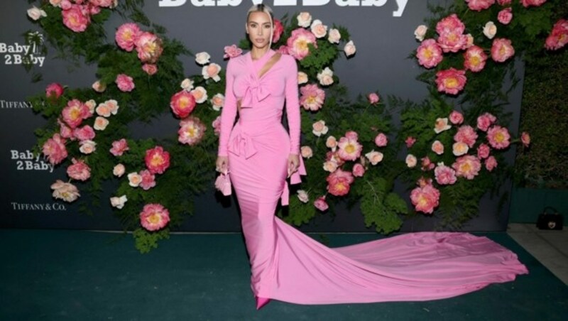 Kim Kardashian in einem pinken Wickelkleid mit langer Schleppe von Balenciaga (Bild: 2022 Getty Images)