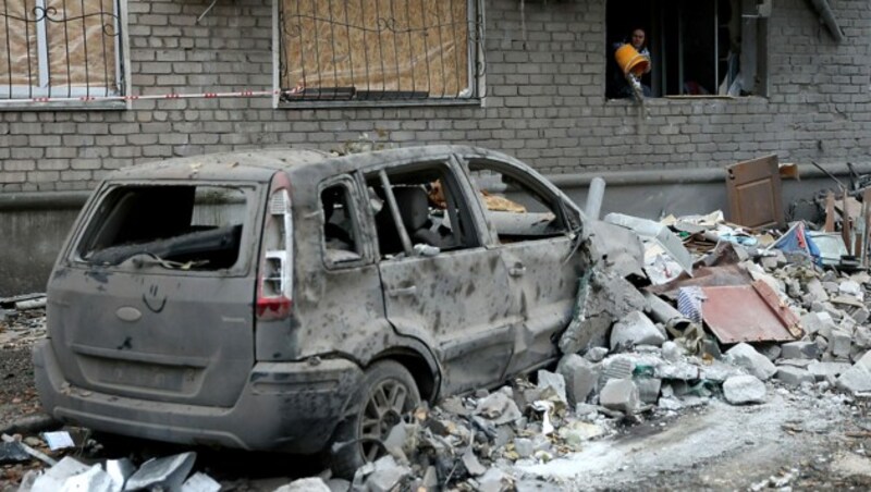 Eine zurückgekehrte Bewohnerin beim Aufräumen in einem teilweise zerstörten Wohnhaus in Mykolajiw (Bild: APA/AFP/Anatolii STEPANOV)