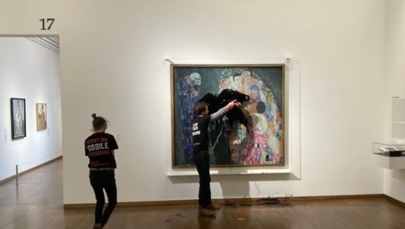 Ein Klimaaktivist und eine Klimaaktivistin der „Letzten Generation“ vor dem Klimt-Gemälde im Leopold Museum (Bild: APA/Letzte Generation Österreich)