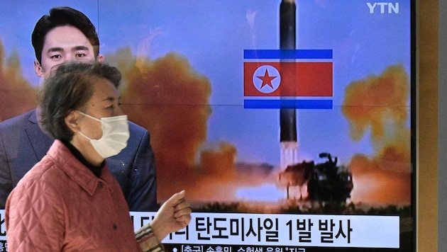 Im Fernseher zeigt ein Nachrichtensender ein Archivfoto eines nordkoreanischen Raketentests (Bild: APA/AFP/Anthony WALLACE)