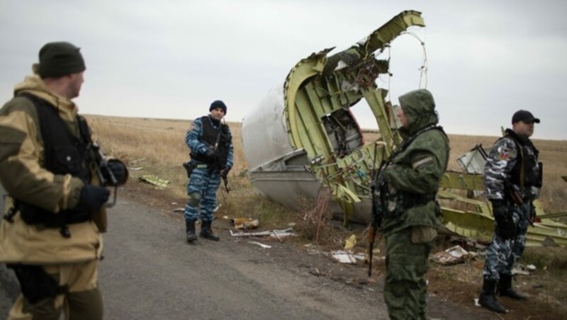 Prorussische Kämpfer bewachen das Wrack des abgeschossenen Flugzeugs (Archivbild November 2014). (Bild: APA/AFP/Menahem KAHANA)