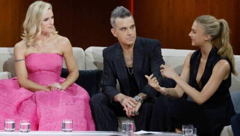 Schauspielerin Lilly Krug (r.) plaudert mit Sänger Robbie Williams. Im pinken Kleid: Moderatorin Michelle Hunziker (Bild: Philipp von Ditfurth / dpa / picturedesk.com)