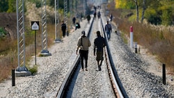 Migranten gehen auf den Bahngleisen nahe der Grenzlinie zwischen Serbien und Ungarn (Bild: The Associated Press)