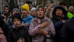 Einwohner singen während einer Versammlung in der Innenstadt von Cherson die ukrainische Nationalhymne. (Bild: Associated Press)