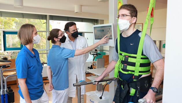 Die Experten (re. Prim Kranz) stellen das Gerät ein, auf dem Dr. Bernhard Wolf trainiert. (Bild: Peter Tomschi)