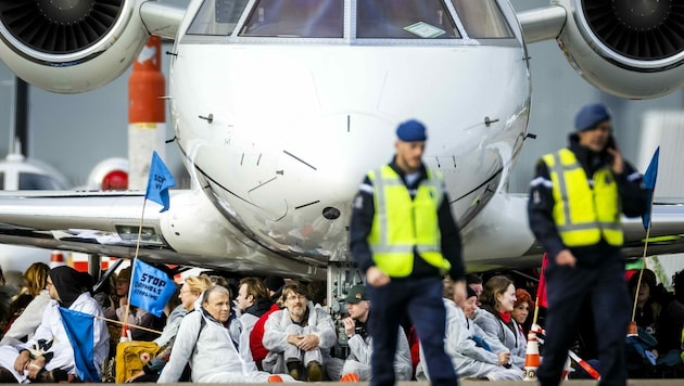 An Fahrwerke gekettet verbrachten Aktivisten zuletzt zwei Tage am Flughafen in Amsterdam. (Bild: AFP)