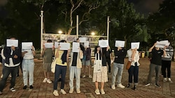 Studierende hielten weiße Blätter hoch und sangen „Wider die Diktatur“, um gegen Chinas Antivirenkontrollen zu protestieren. (Bild: AP)