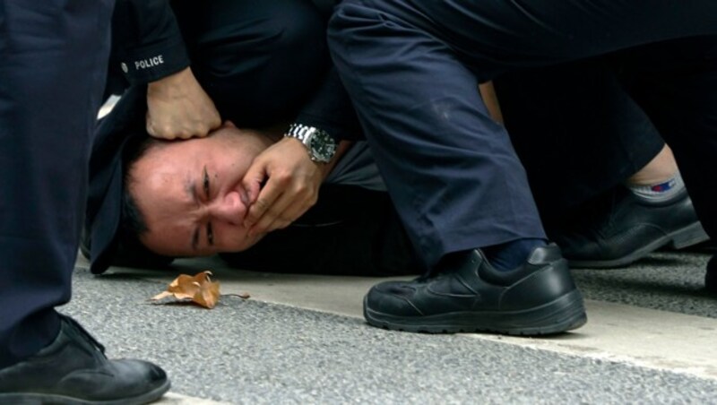 Ein niedergerungener Demonstrant in Shanghai (Bild: AP)