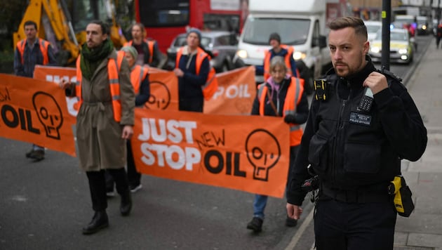 Ein britischer Polizist überwacht eine Klimademo in London. (Bild: APA/AFP/Daniel Leal)