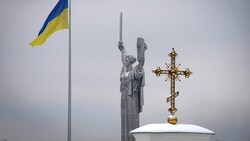 Kiewer Dreifaltigkeit: die Staatsflagge, die Mutter-Heimat-Statue und ein golden schimmerndes Kreuz auf dem berühmten Höhlenkloster (Bild: ASSOCIATED PRESS)