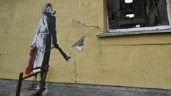 Dieses Banksy-Werk prangt nicht mehr an dieser Hausfassade in Hostomel. (Bild: APA/AFP/Genya Savilov)