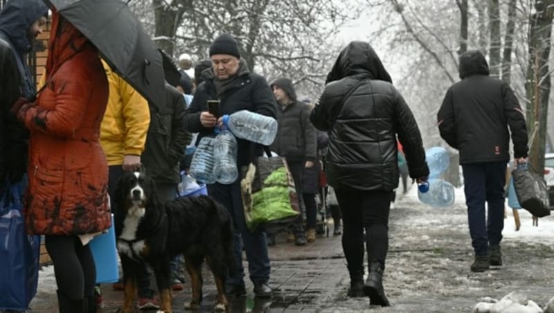 Ukrainer stehen Schlange vor einer Wasserpumpe in einem Park, um Plastikflaschen abzufüllen. Die Ukraine kämpft um die Wiederherstellung ihrer zerstörten Strom- und Wasserversorgung. (Bild: AFP)