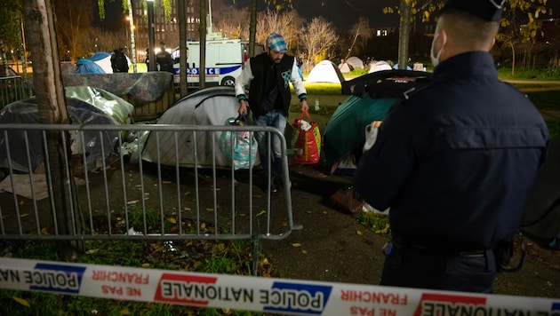 Ein Migrant trägt eine Tasche während der Räumung eines Lagers vor dem Rathaus in Straßburg (Bild: AFP)