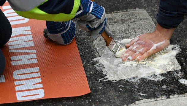 Klima-Kleber der „Letzten Generation“ blockieren eine Straße in München (Archivbild) (Bild: AFP)