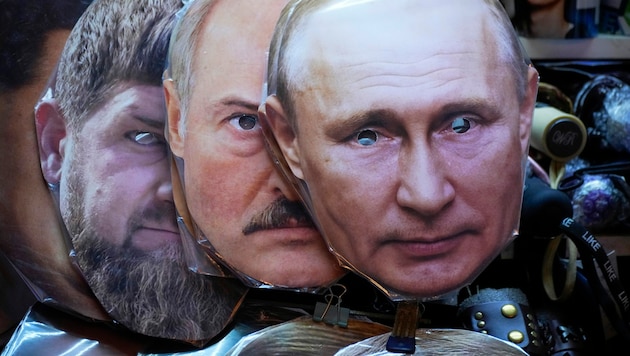Immer wieder wurde spekuliert, ob Lukaschenko (Maske in der Mitte) an Seite Putins in den Krieg ziehen wird. Nun lässt der belarussische Machthaber seine Truppen auf ihre Kampfbereitschaft überprüfen. (Bild: AP/Dmitri Lovetsky)
