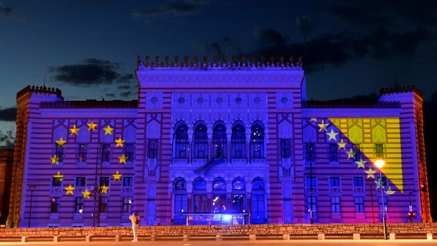 Das Rathaus von Sarajewo angestrahlt mit den Flaggen von EU und Bosnien-Herzegowina (Archivbild). (Bild: APA/AFP/ELVIS BARUKCIC)