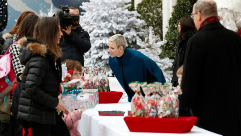 Fürstin Charlène verteilt bei der Weihnachtsbaumzeremonie in Monaco Geschenke. (Bild: APA/Photo by Sebastien NOGIER/AFP)